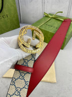 Gucci GG canvas belt with red leather strap and close-up of ornate gold buckle