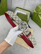 Gucci GG canvas belt with red leather strap and large circular buckle, front close-up