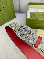 Gucci GG canvas belt with red leather strap and large silver buckle, angled view