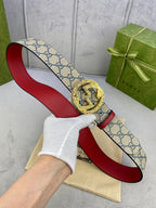 Gucci GG canvas belt with red leather underside and gold-tone buckle, held open