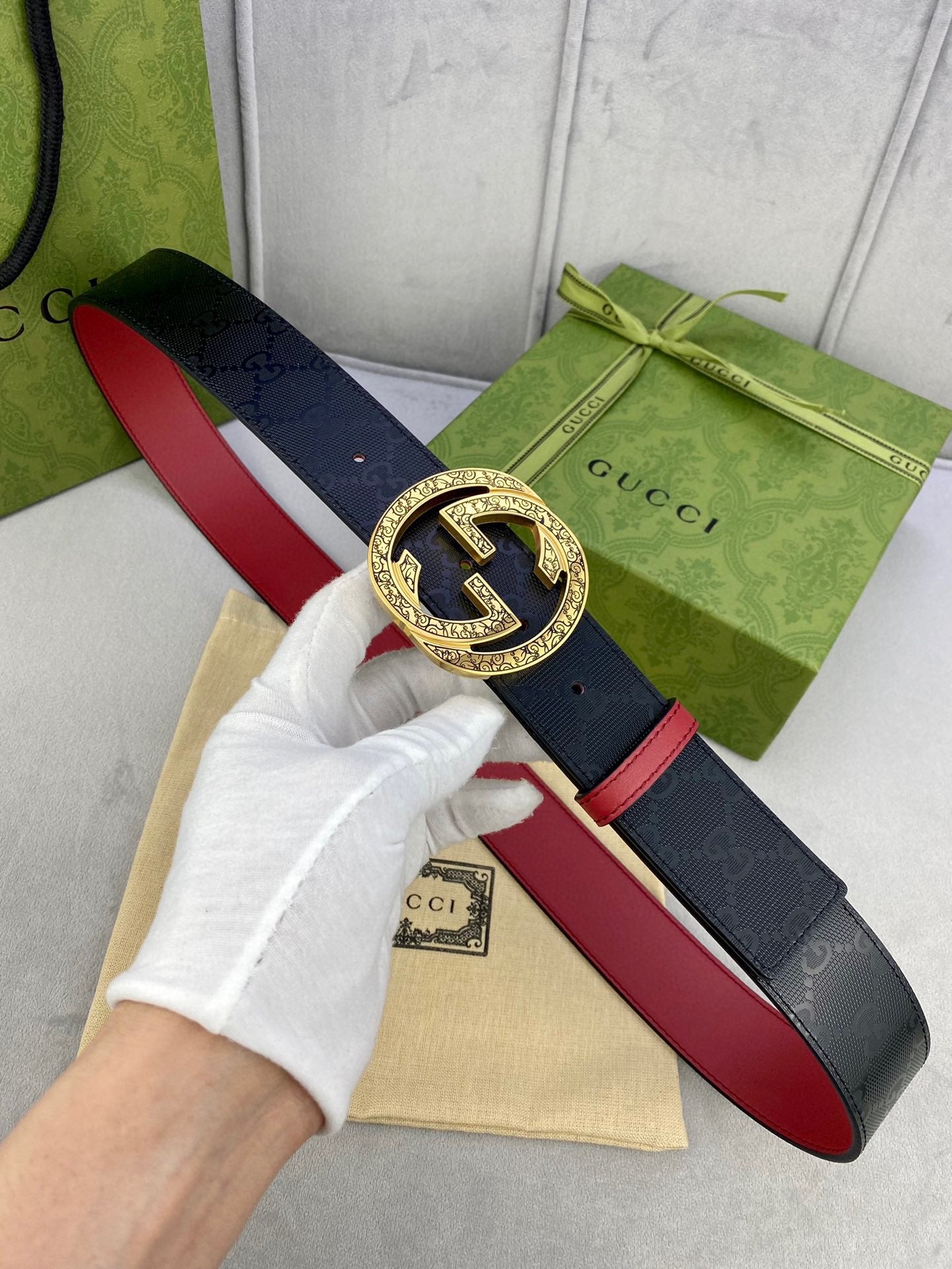 Gucci belt with gold-tone G buckle, dark strap and red leather underside