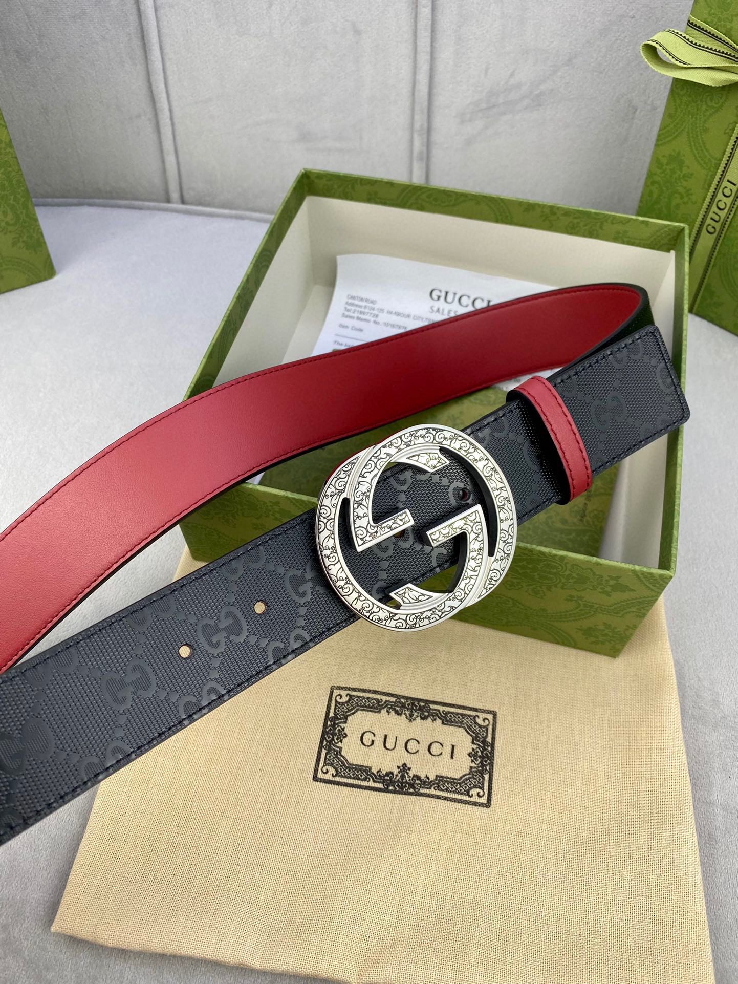 Gucci belt with dark logo strap, red underside, ornate gold-tone G buckle