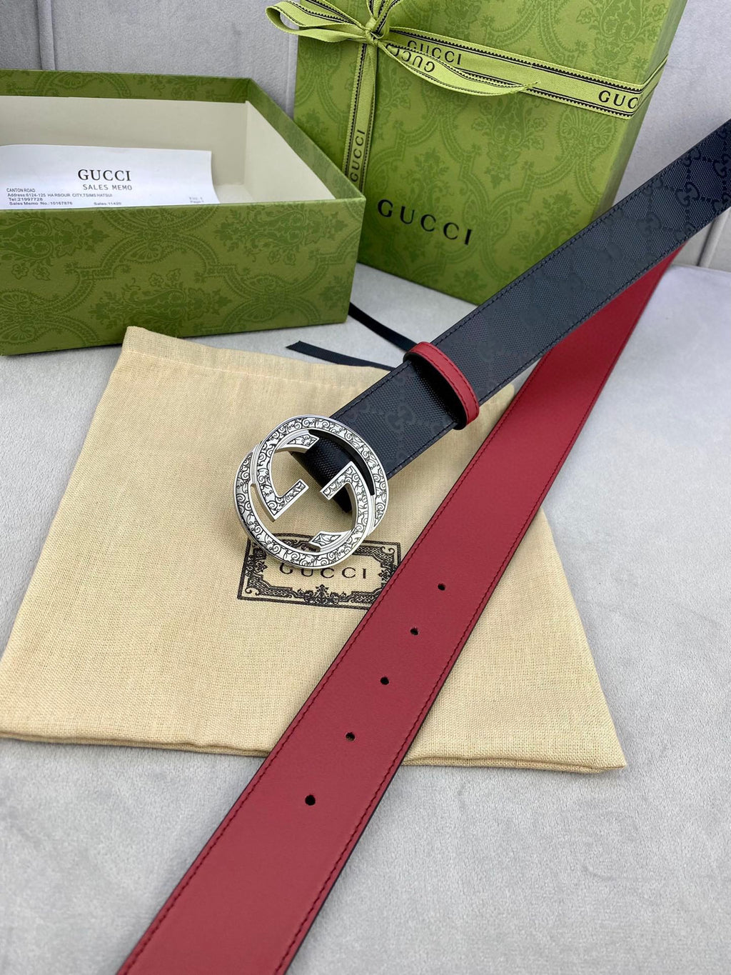 Gucci belt close-up with red leather strap and gold-tone G buckle