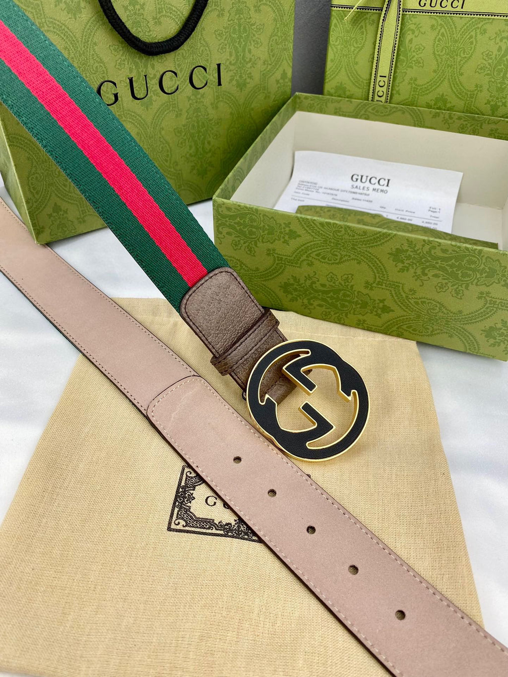 Gucci belt with beige leather, green-and-red web stripe, and round gold-tone GG buckle.