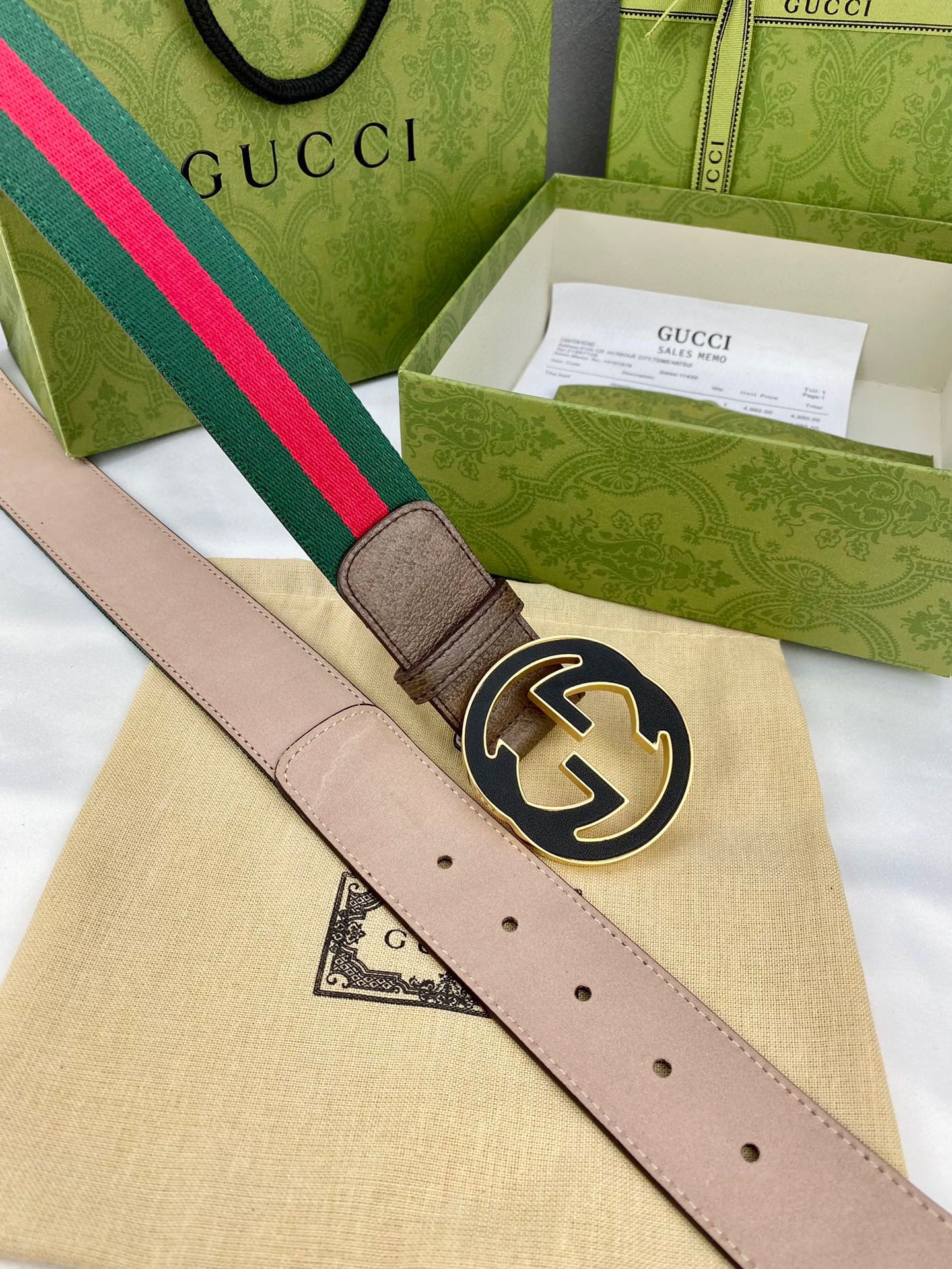 Gucci belt with beige leather, green-and-red web stripe, and round gold-tone GG buckle.