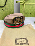Gucci belt featuring brown leather strap, green and red web stripe, and round gold-tone buckle.