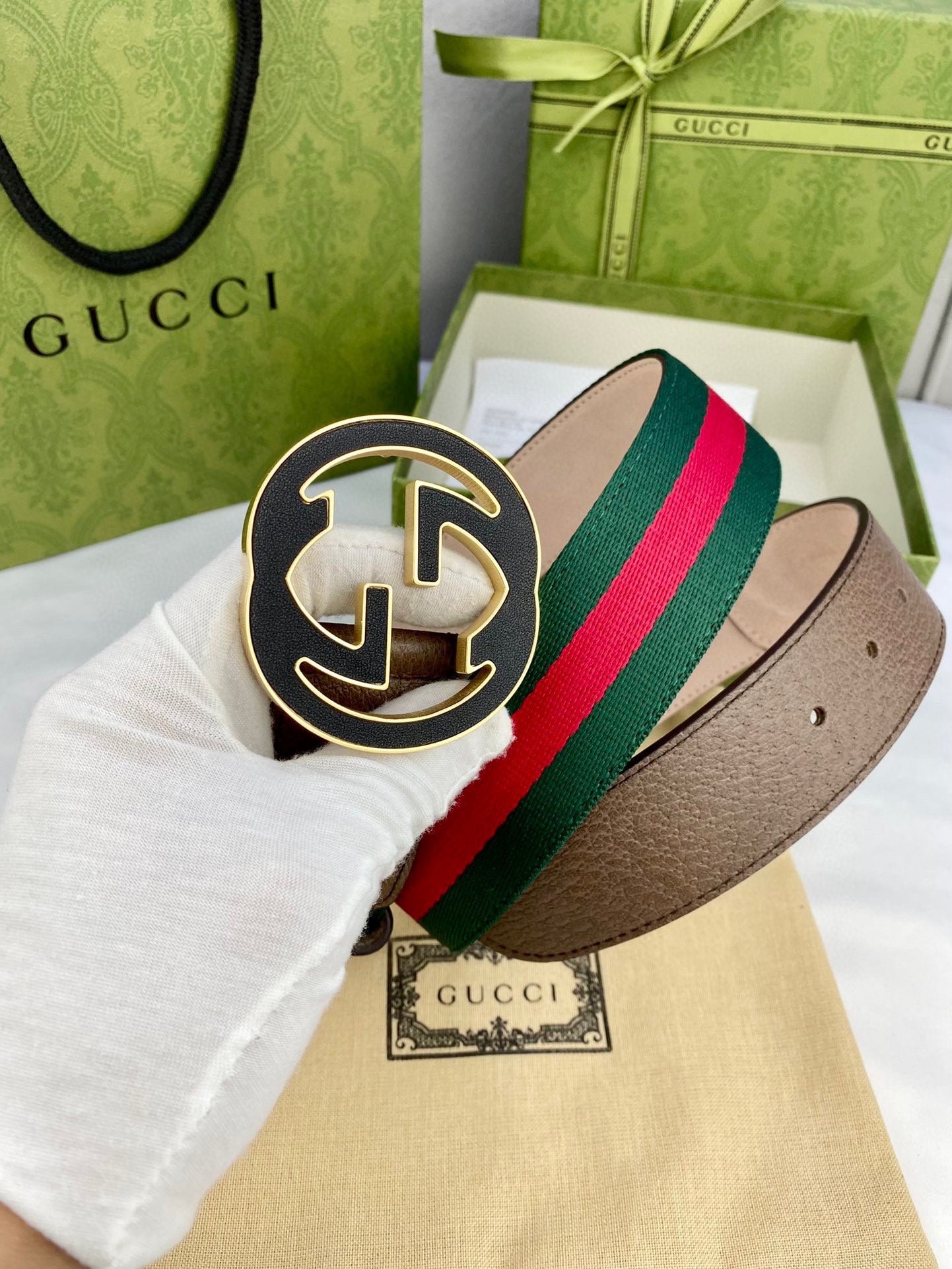 Gucci belt detail with dark brown leather and multicolor web stripe, featuring a gold-tone buckle.