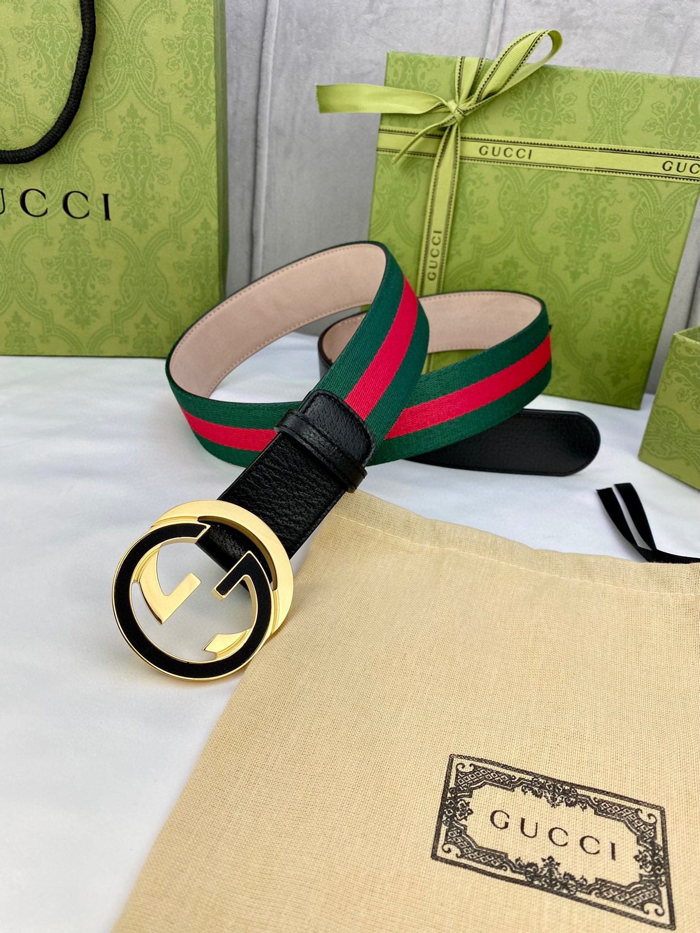 Black leather belt with gold-tone GG buckle and green-red web strap