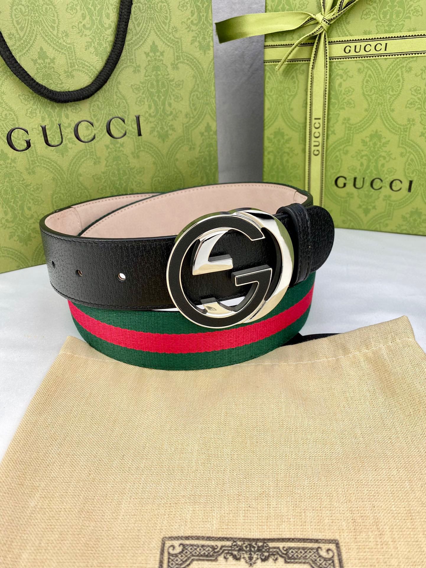 Black leather belt with gold-tone GG buckle and green-red web stripe band