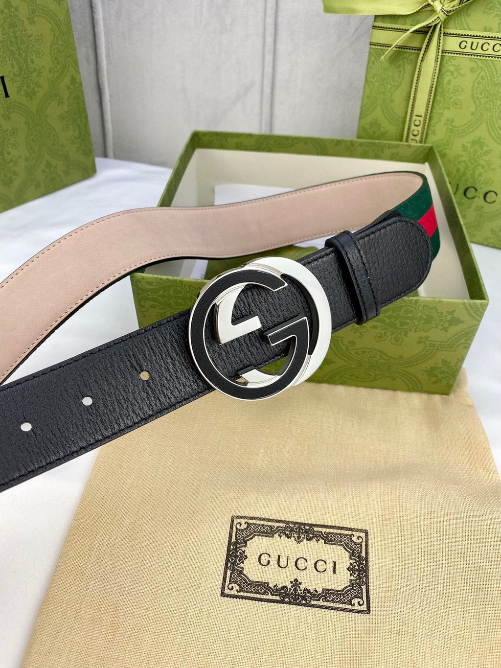 Black leather belt with gold-tone GG buckle and green-red web stripe detail