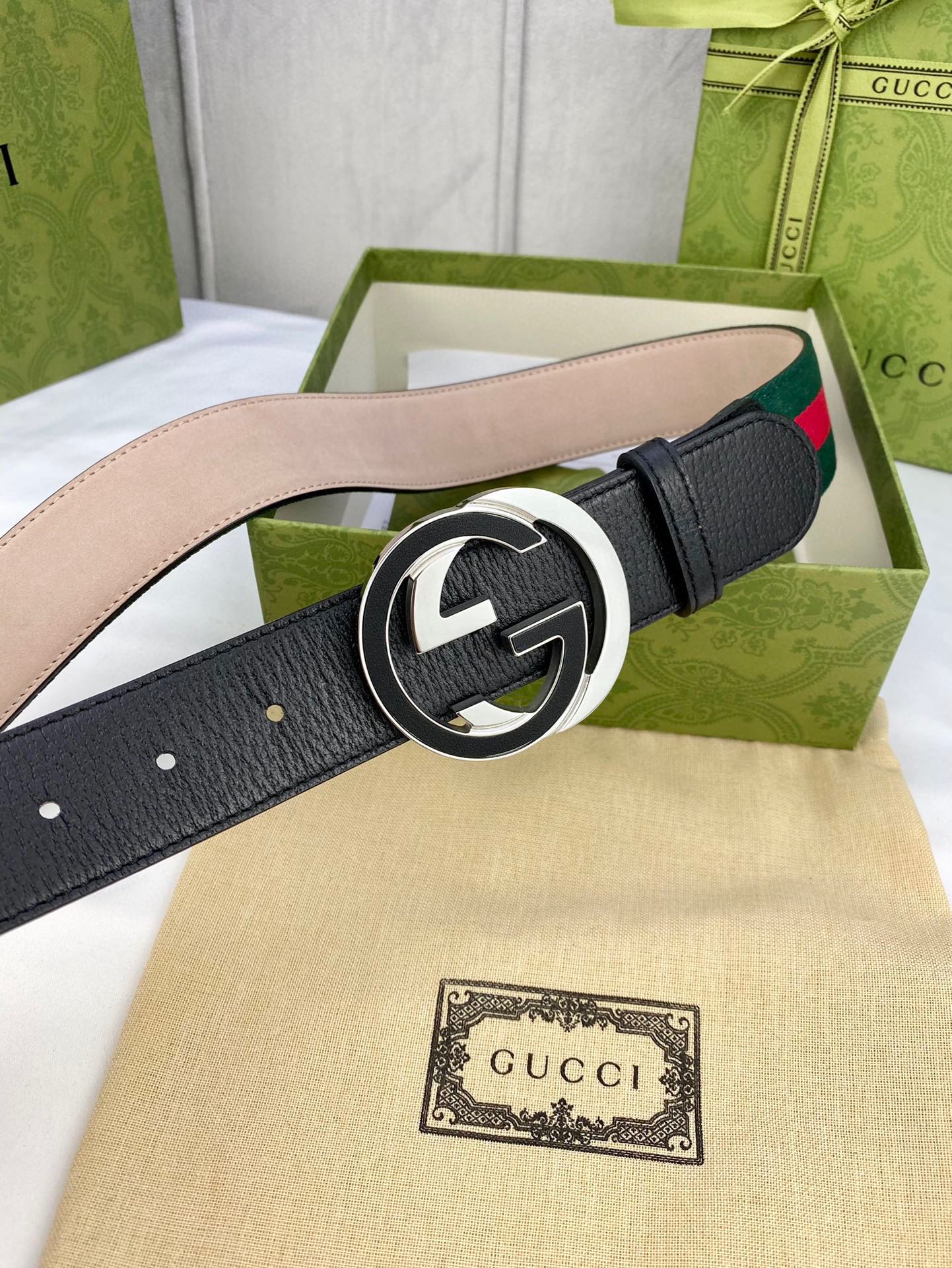 Black leather belt with gold-tone GG buckle and green-red web stripe detail