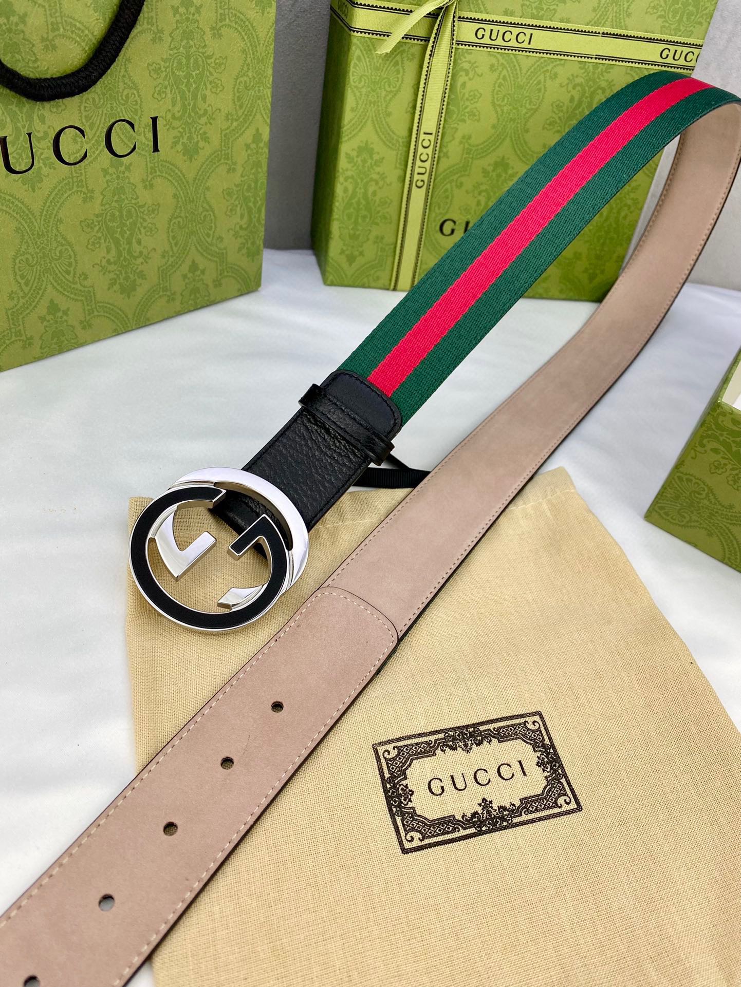 Leather belt with gold-tone GG buckle, light interior, and green-red web stripe