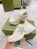 White Gucci unisex sneakers with blue star and GG logo, lace-up front angle