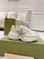 White Gucci unisex sneakers with blue star and yellow GG logo, lace-up design