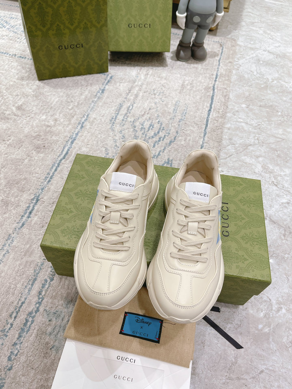 White Gucci unisex sneakers with blue star GG logo, lace-up front view