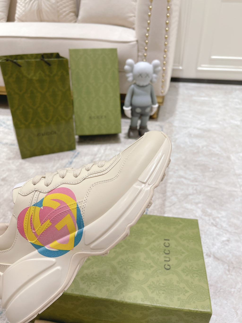 White Gucci unisex sneaker with multicolor GG heart logo, side close-up