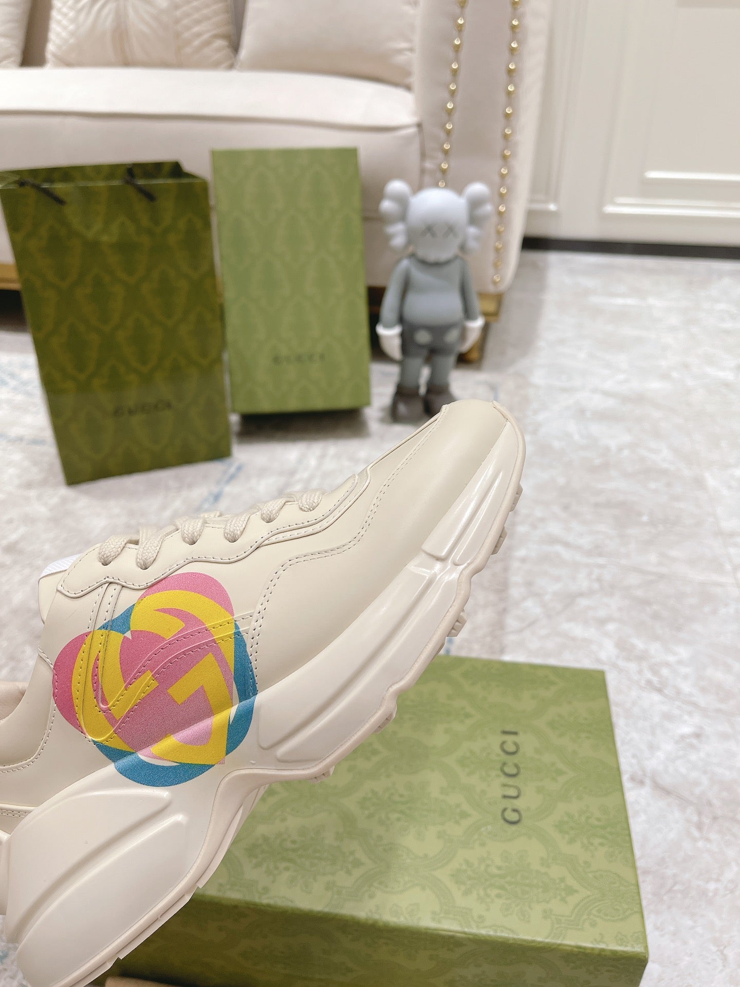 White Gucci unisex sneaker with multicolor GG heart logo, side close-up