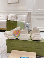 White Gucci unisex sneakers on shoebox, multicolor GG heart logo visible
