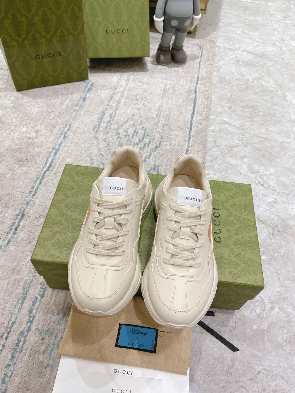 Pair of white Gucci unisex sneakers on shoebox, lace-up style