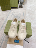 Pair of white Gucci unisex sneakers on shoebox, lace-up style