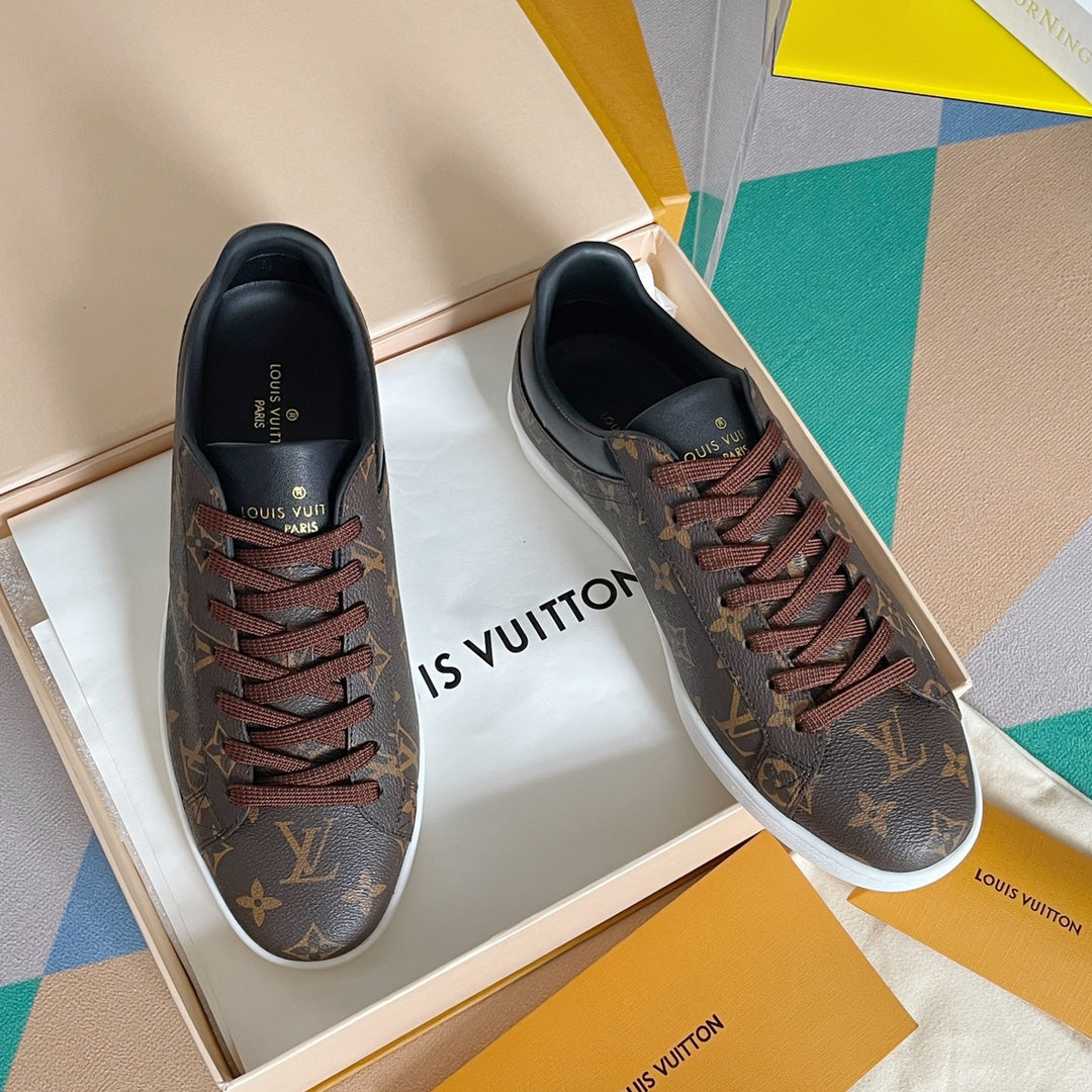 Louis Vuitton unisex sneakers in monogram canvas with brown laces and white sole.
