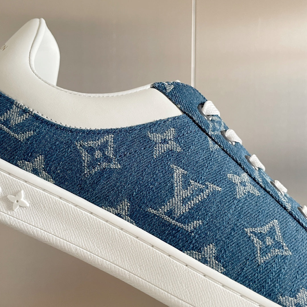 Louis Vuitton blue denim sneaker with white sole and monogram pattern, side close-up