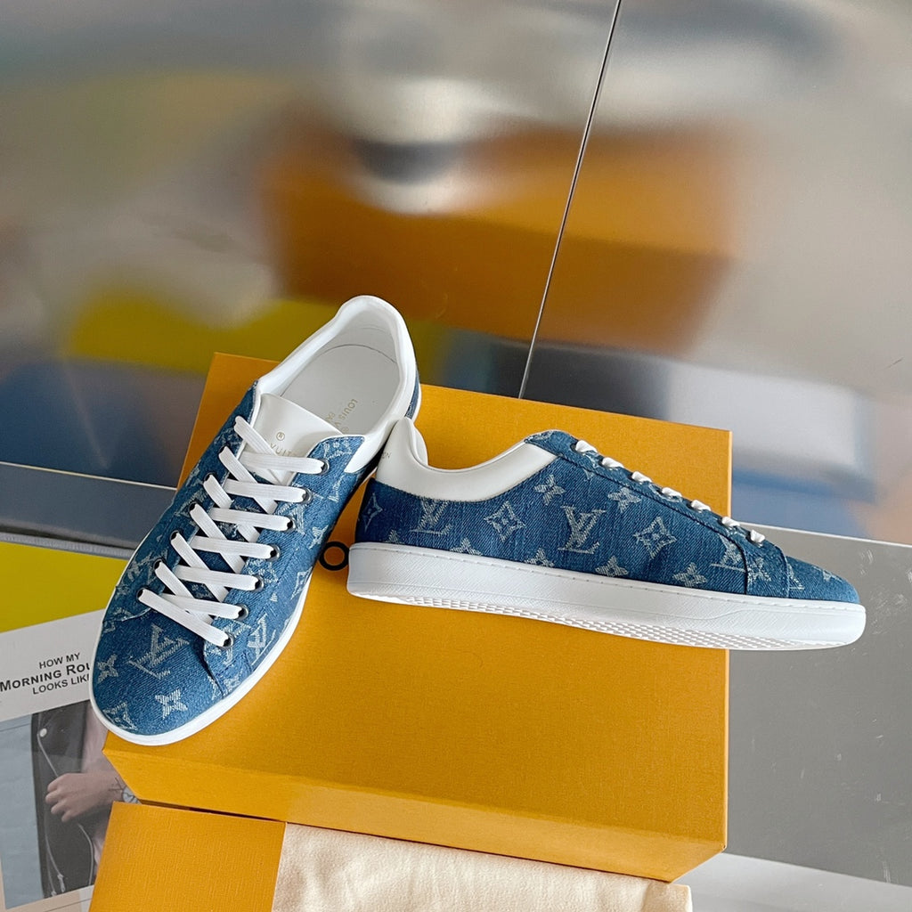 Louis Vuitton blue denim sneakers with white laces and monogram pattern, angled