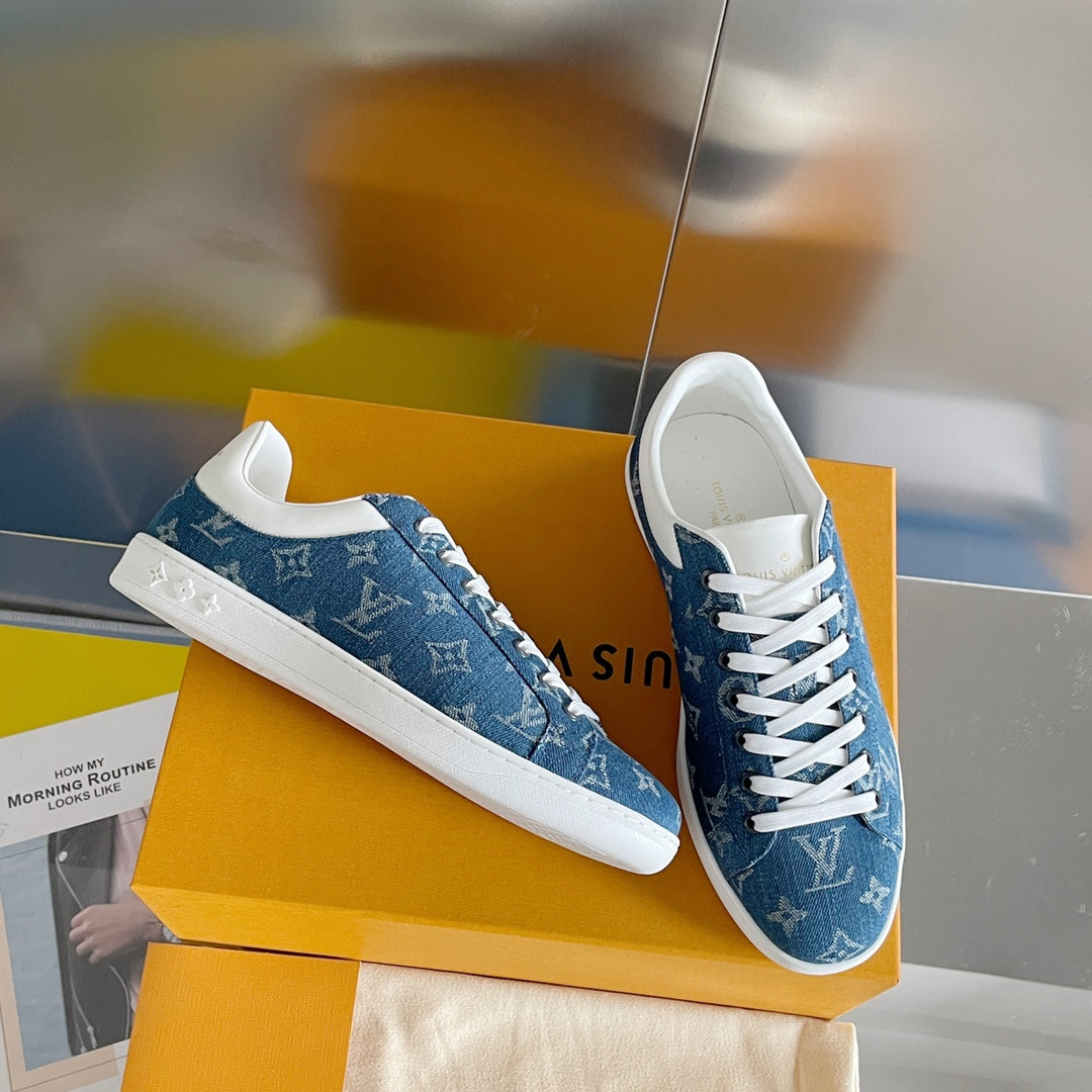 Louis Vuitton denim-blue sneakers with white laces and monogram pattern, side view