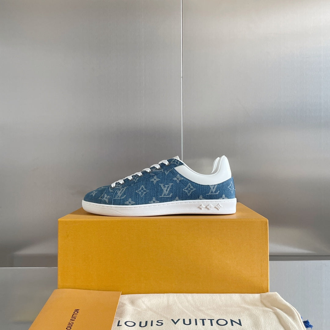 Louis Vuitton blue denim low-top sneakers on yellow box, white laces