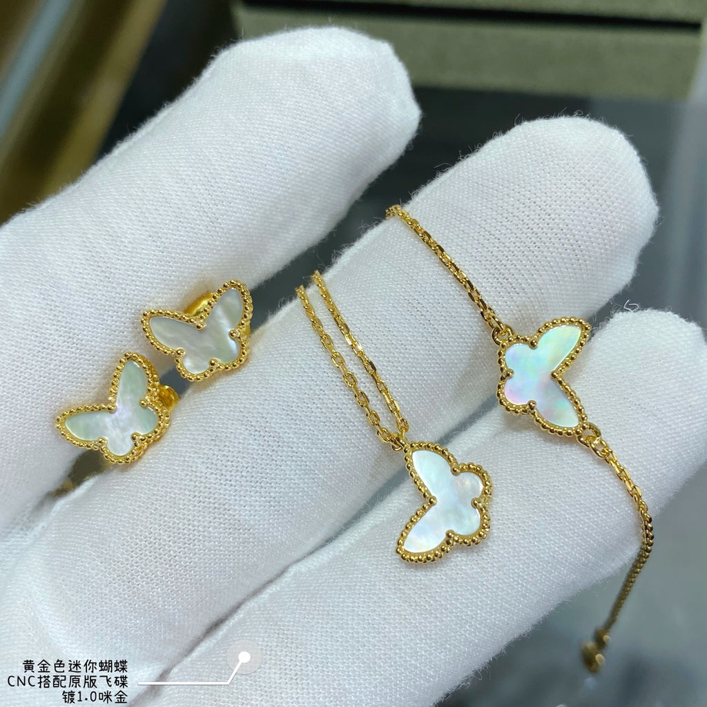 Gold butterfly earrings held in white fabric gloves