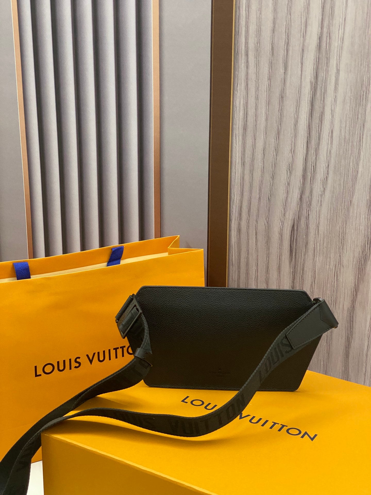 Louis Vuitton crossbody bag, dark leather flap style with shoulder strap and LV emblem