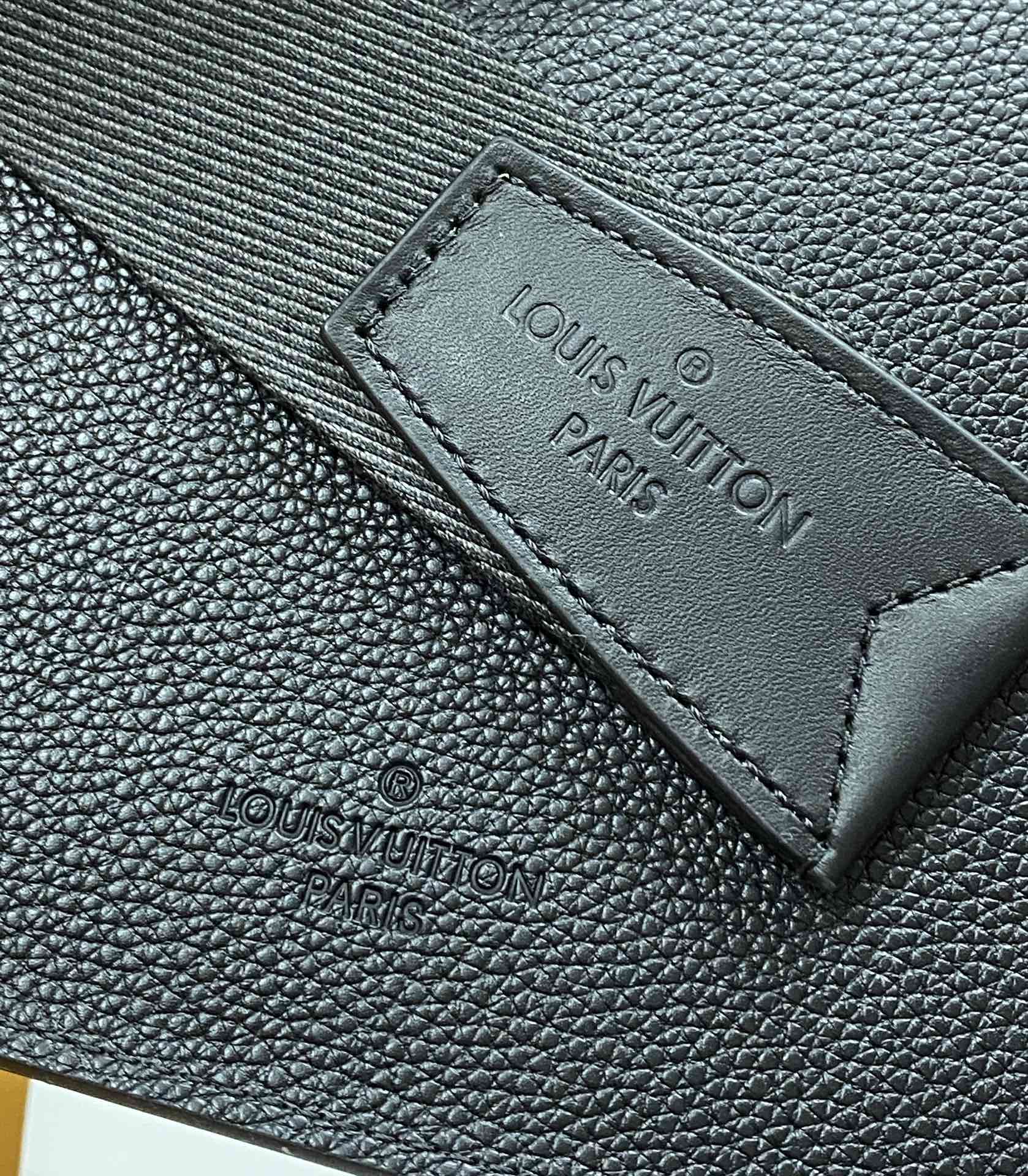 Louis Vuitton bag interior label on dark pebbled leather with stitched border