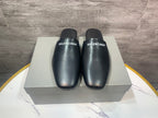 Black leather slide sandals on a box, BALENCIAGA logos on front straps