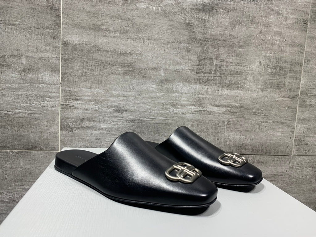 Pair of black leather slide sandals with silver buckle detail
