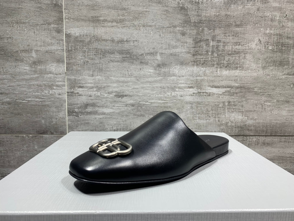 Black leather slide sandal with silver buckle hardware, side view