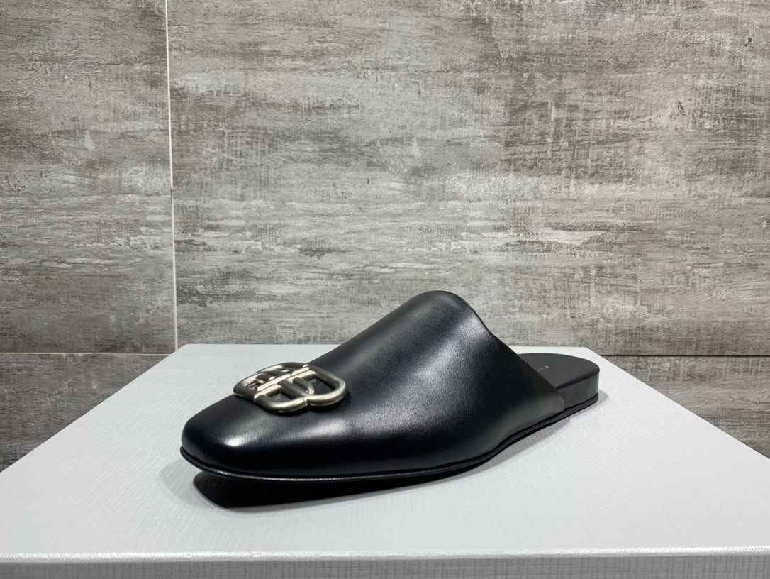 Black leather slide sandal with silver buckle hardware, side view