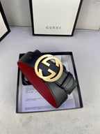 Black leather belt with gold-toned GG buckle and red interior lining