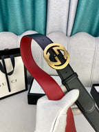 Black leather belt with gold-toned GG buckle, showing red interior edge