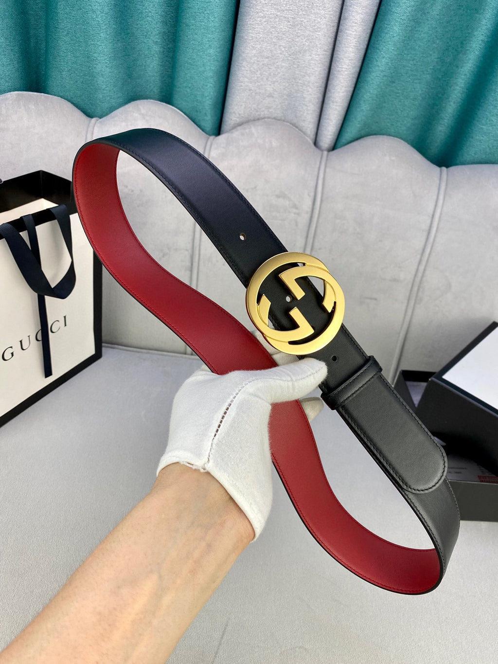 Leather belt with gold-toned GG buckle, black exterior and red underside