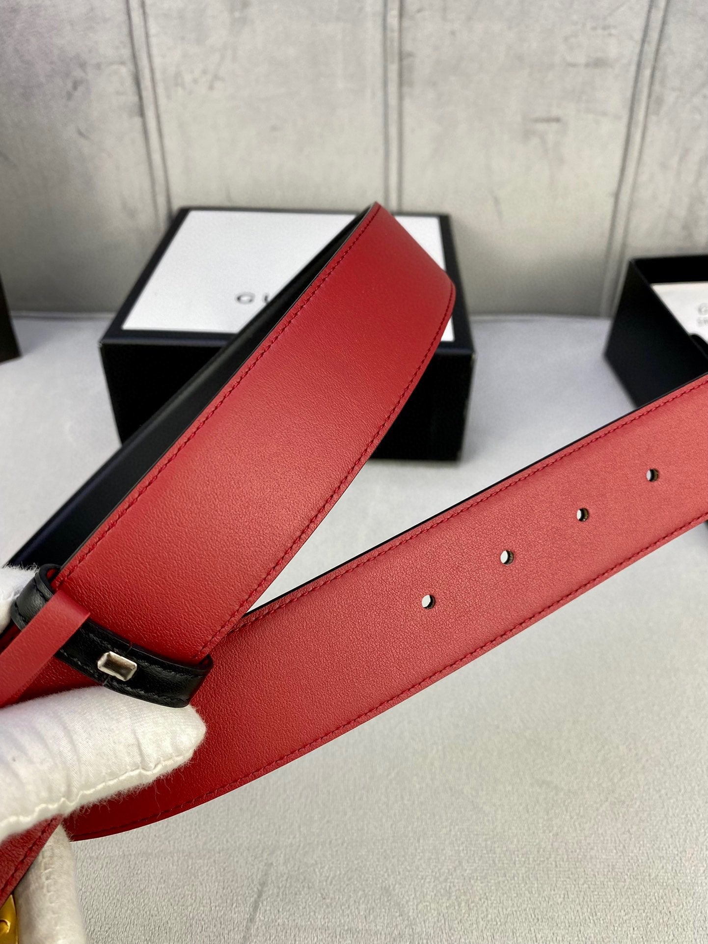 Red leather belt strap with punched holes and small metal hardware