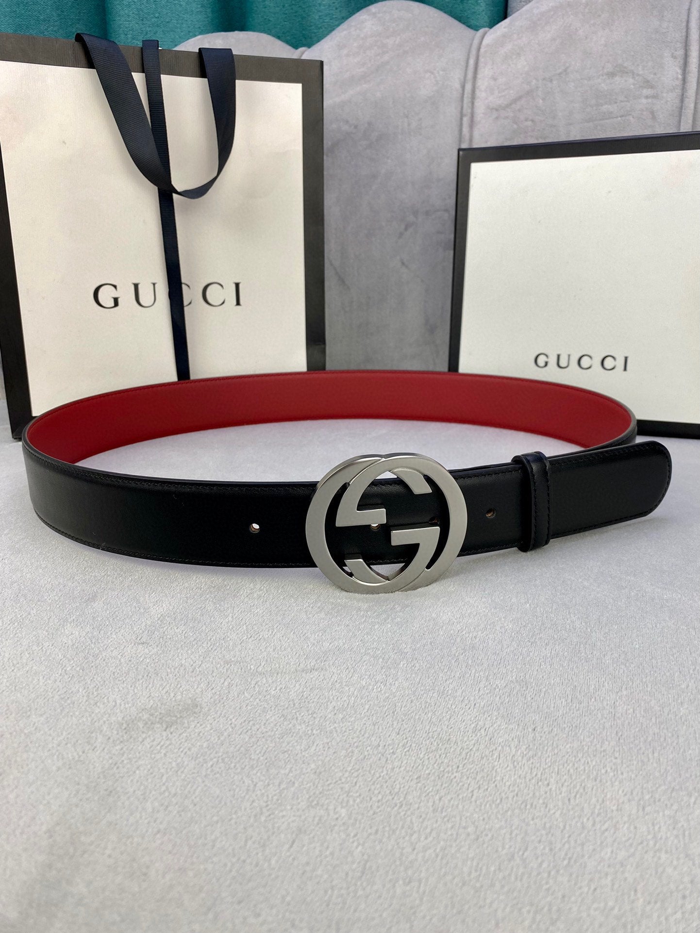 Gucci leather belt with black strap and silver GG buckle, red underside detail