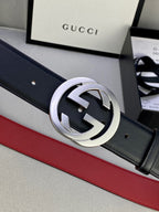 Dark leather belt with silver GG buckle and red trim, close-up on buckle