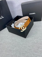 Tan leather belt in box with rhinestone CC buckle on a curved strap