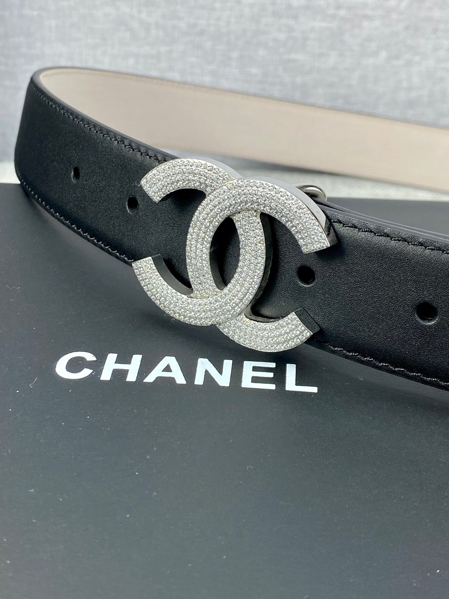 Black leather belt with silver-tone CC logo buckle, detailed glitter finish