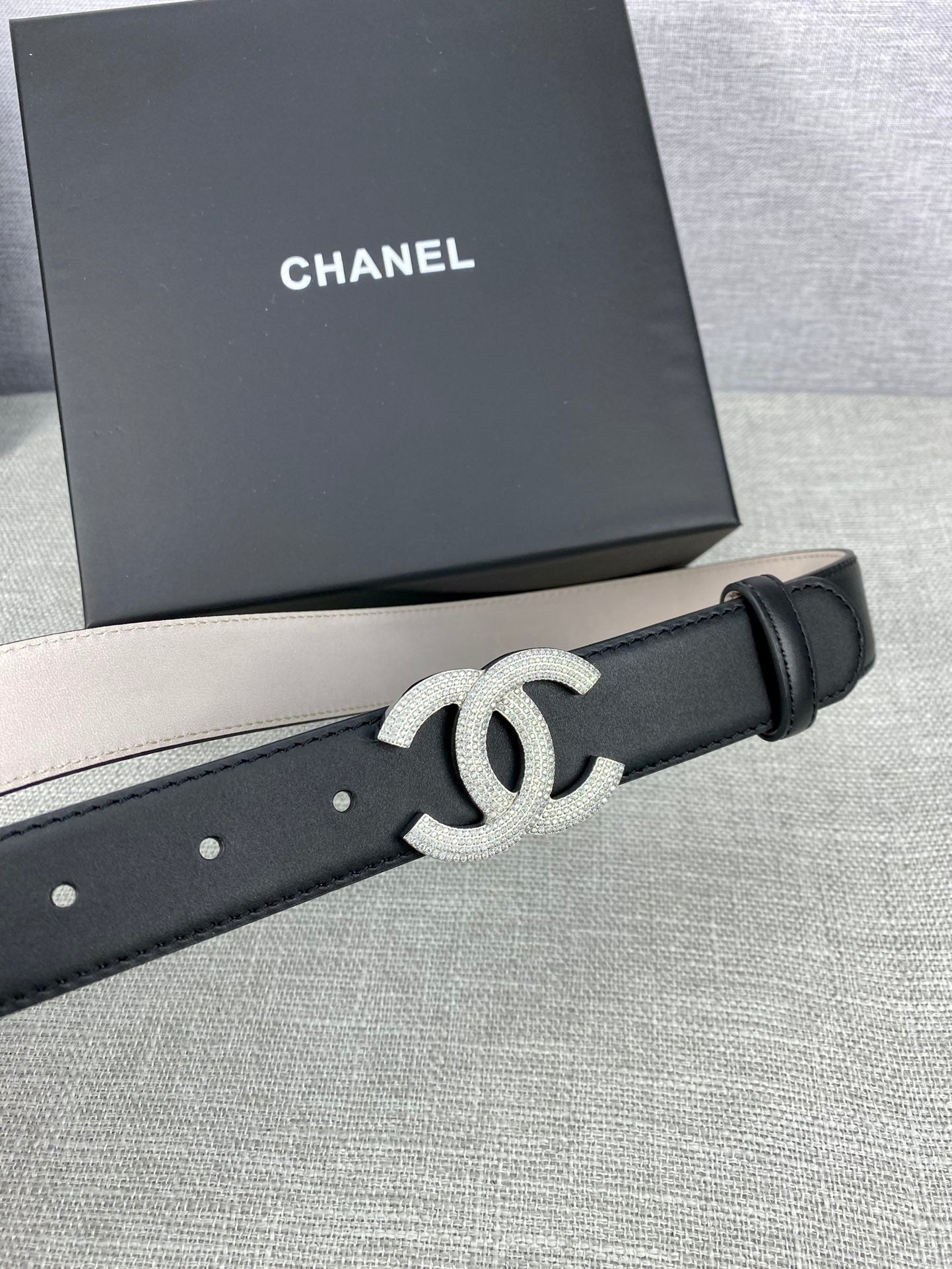 Black leather belt with silver-tone CC buckle and smooth adjustable end