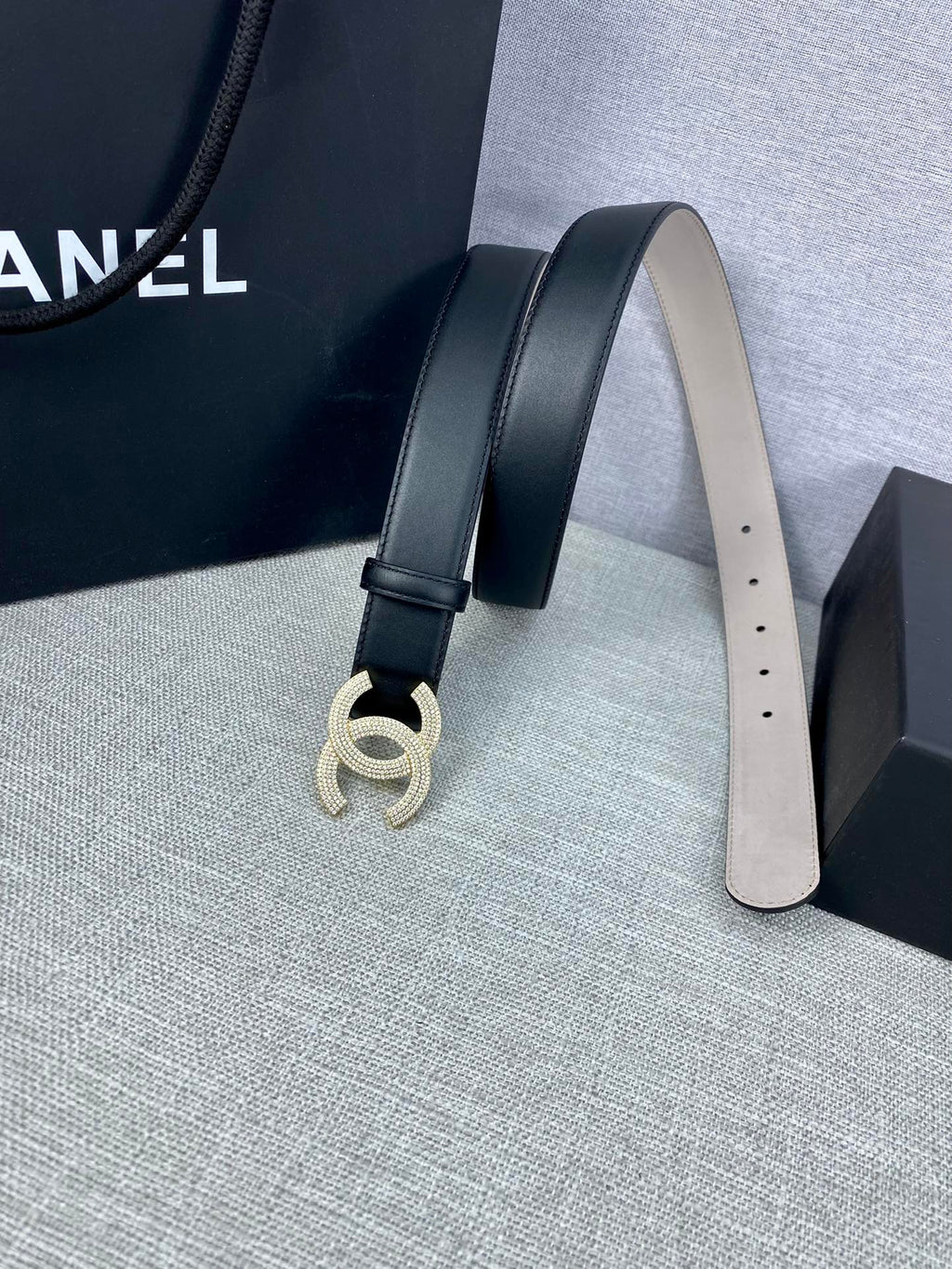Black leather belt with silver-tone CC buckle and punched sizing holes