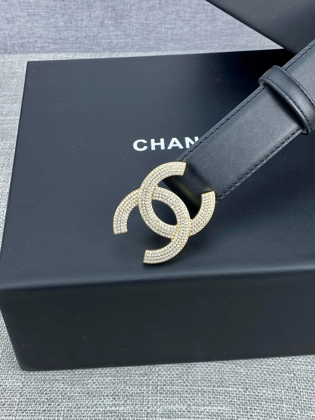 Black leather belt with silver-tone CC buckle on a slim strap