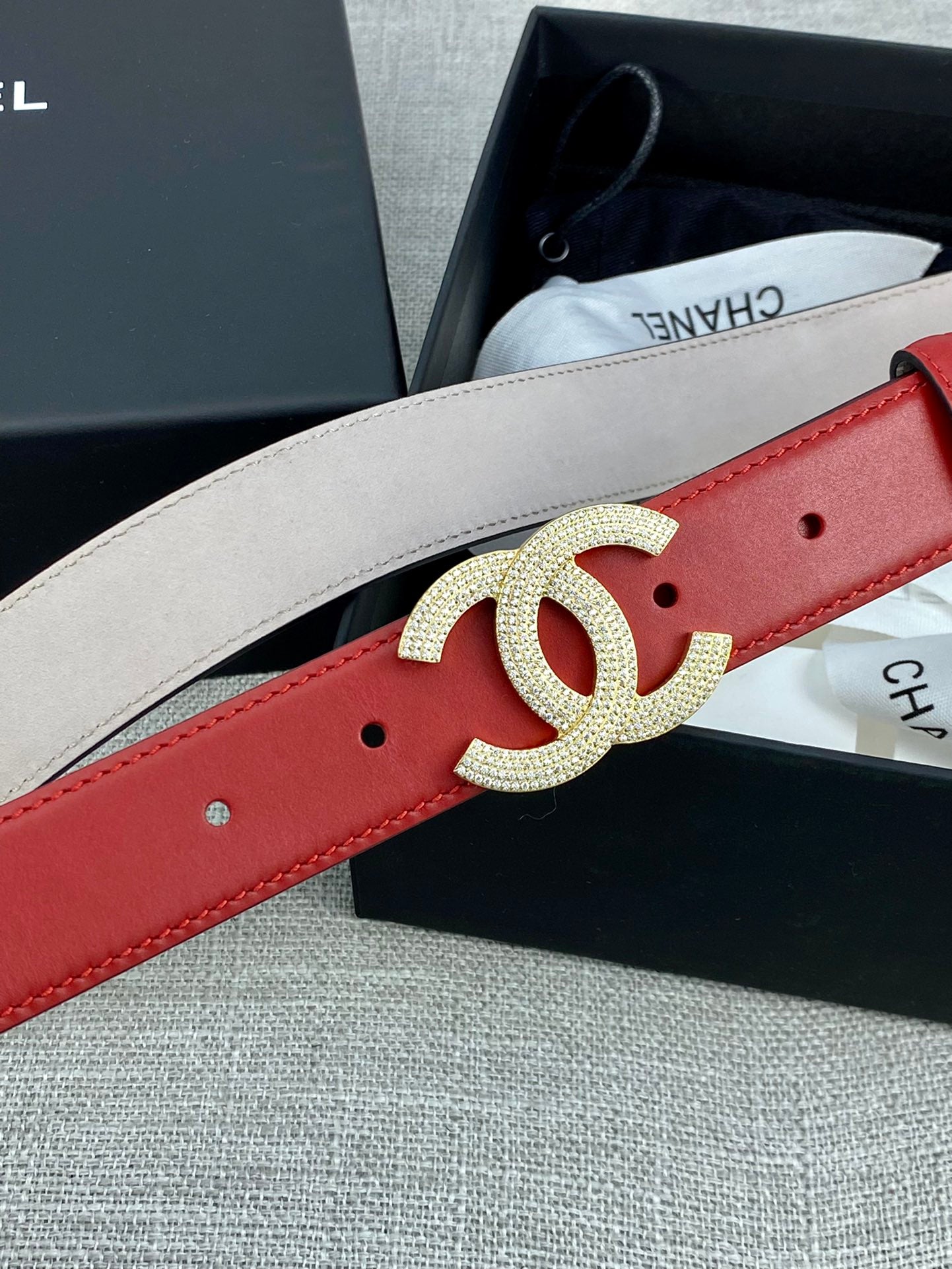 Red belt with gold-tone Double C buckle over light-beige reverse side