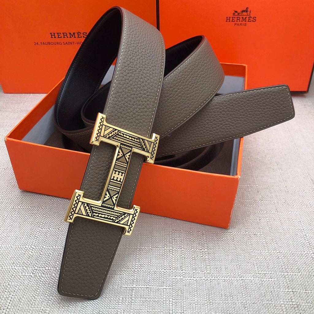 Taupe leather belt with wide silver-tone engraved buckle, extended view
