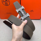 Taupe leather belt held up with silver-tone engraved buckle
